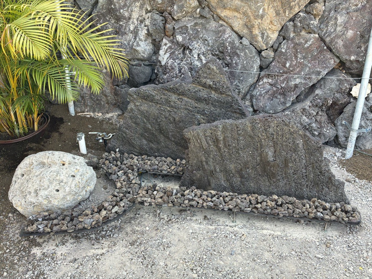 Custom fire strips and bowl installation against lava rock wall