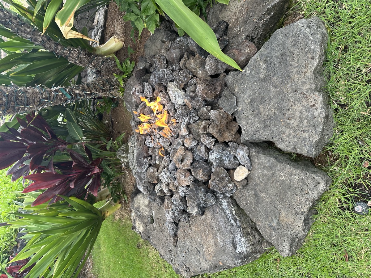 Fire pit with lava rock surround in tropical garden
