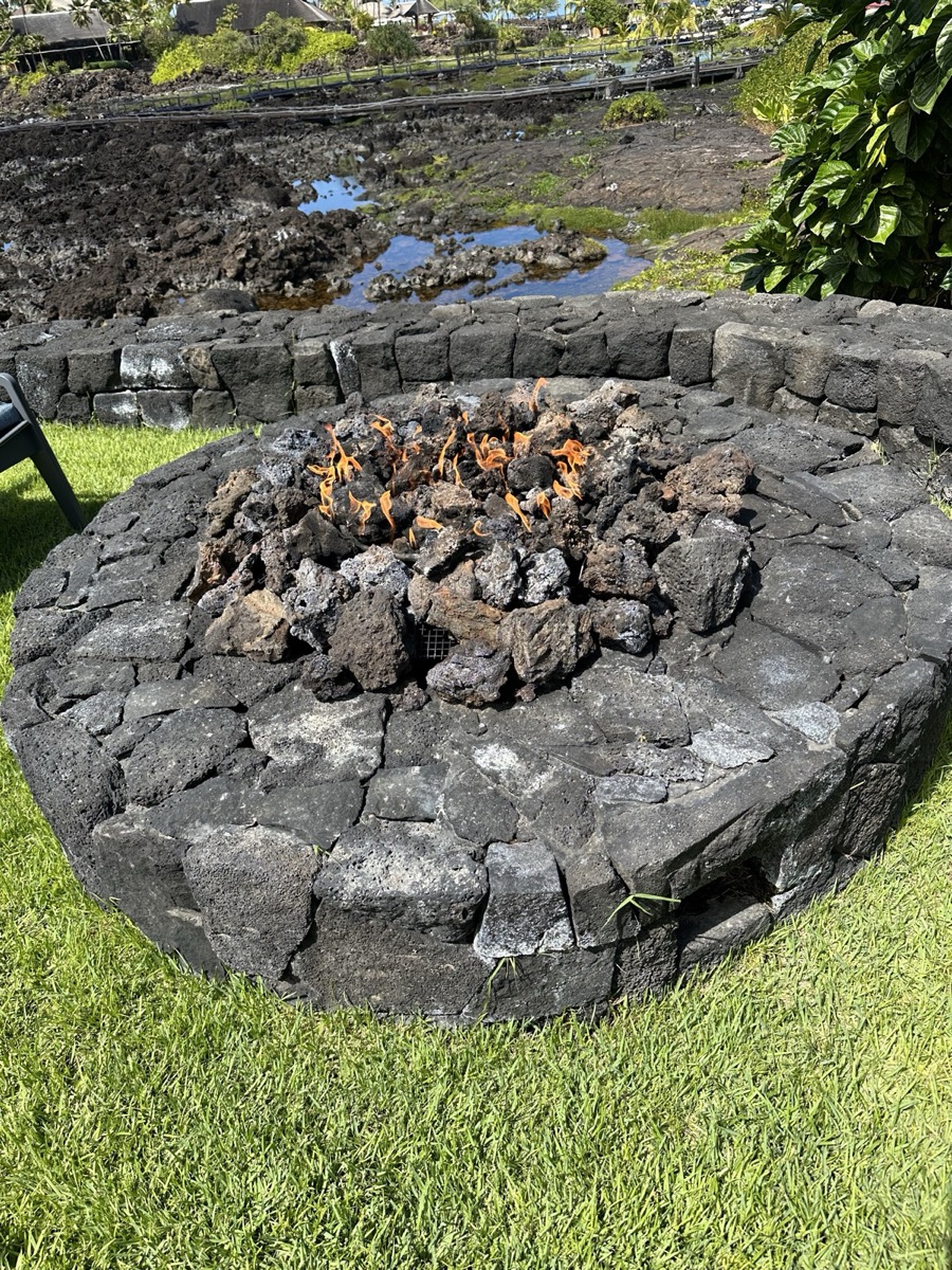 Luxury outdoor patio with lit fire pit and seating